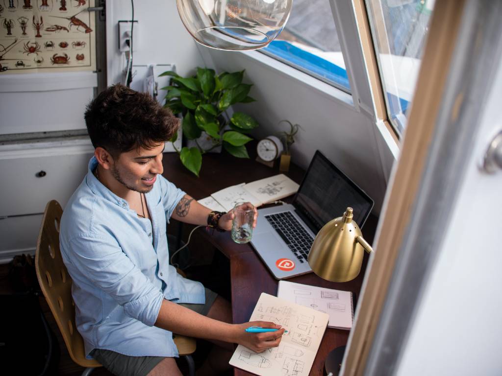 man sitting at desk working on laptop